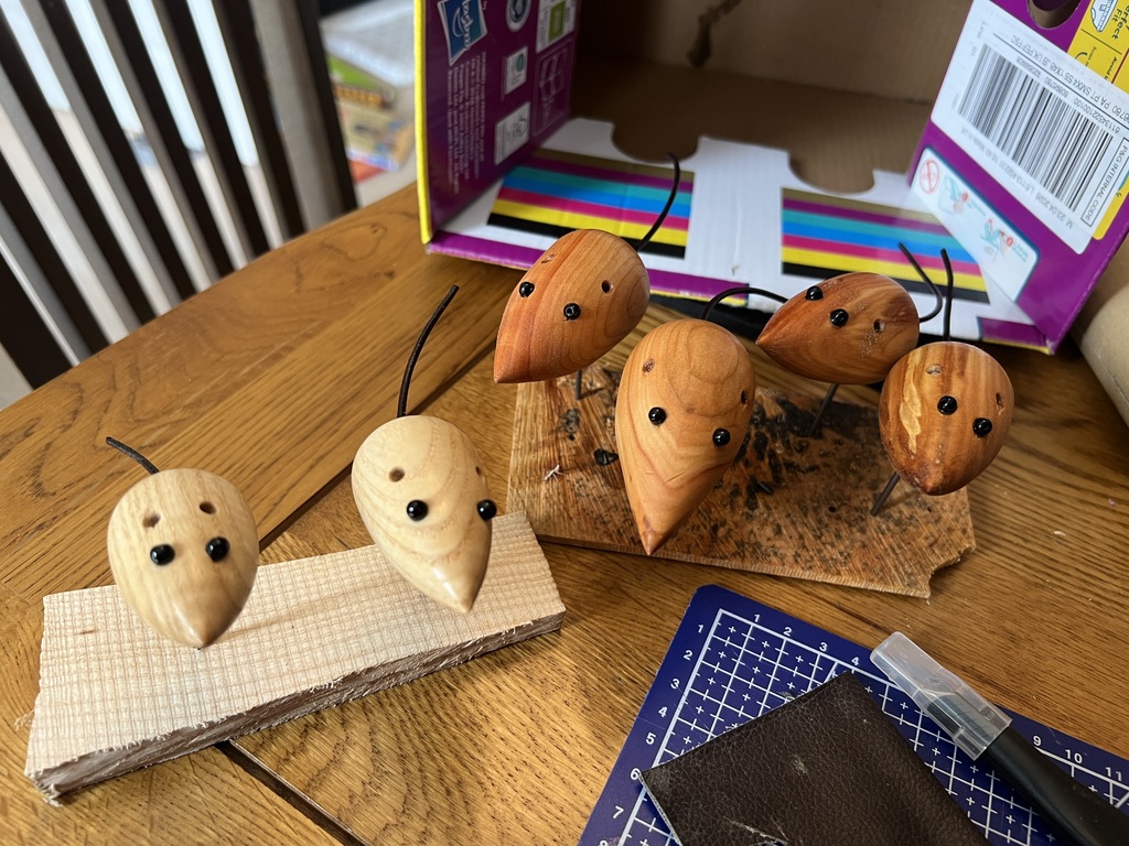 Wooden mouse bodies with beads and leather cord glued in for the eyes and tails